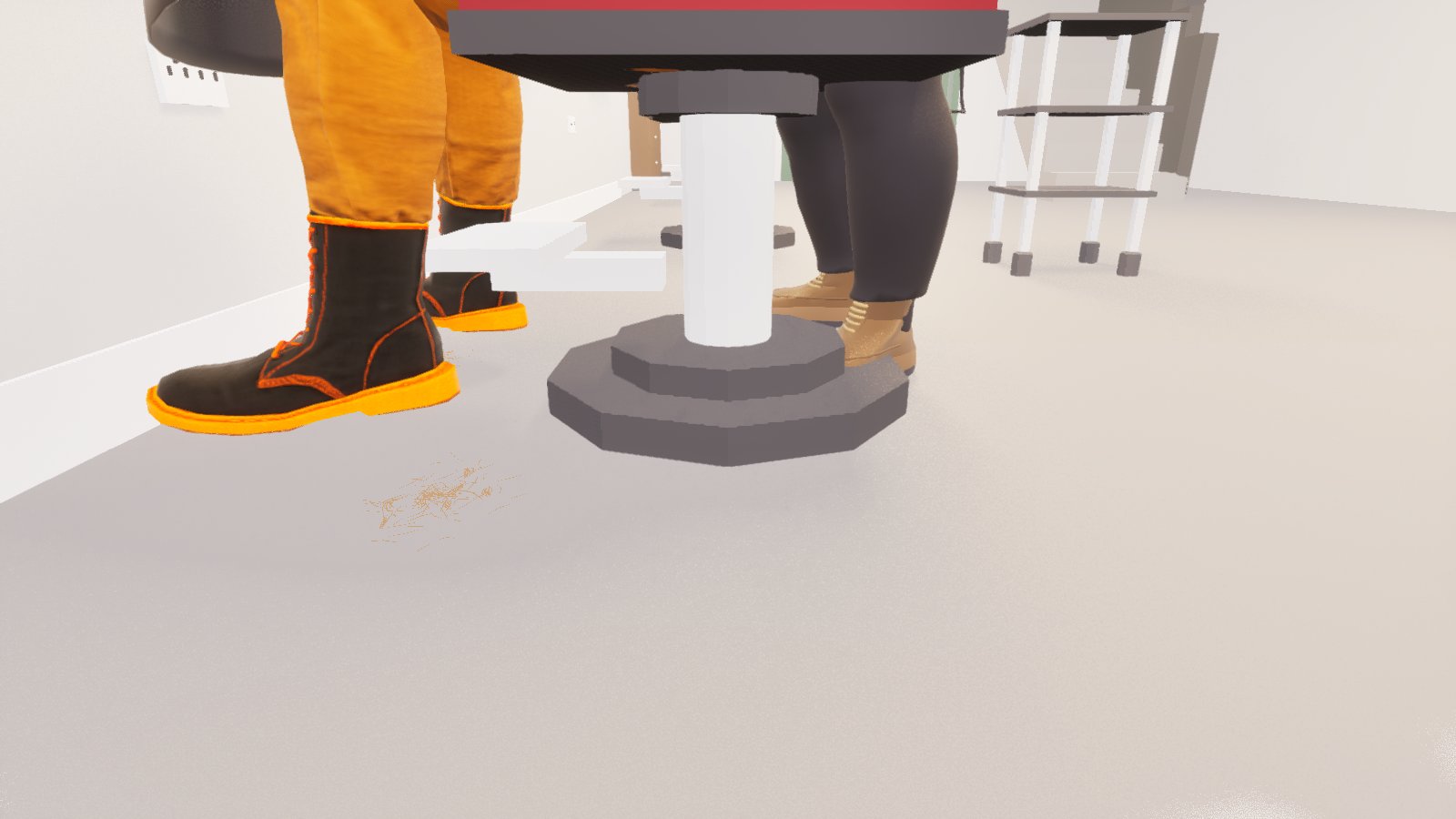 A low shot of a barber's chair base and the feet of the barber and the customer, with a small scatter of fine ginger hair clippings on the grey floor.