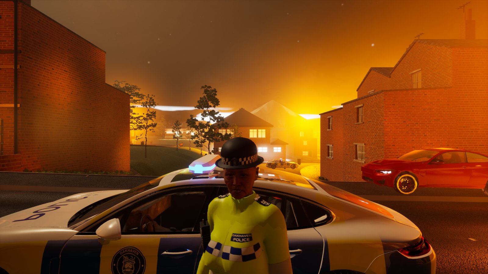 A police officer in a yellow high-visibility jacket and hat beside a police car on a residential street at night, the sky behind the houses glowing orange, a red car parked further along.