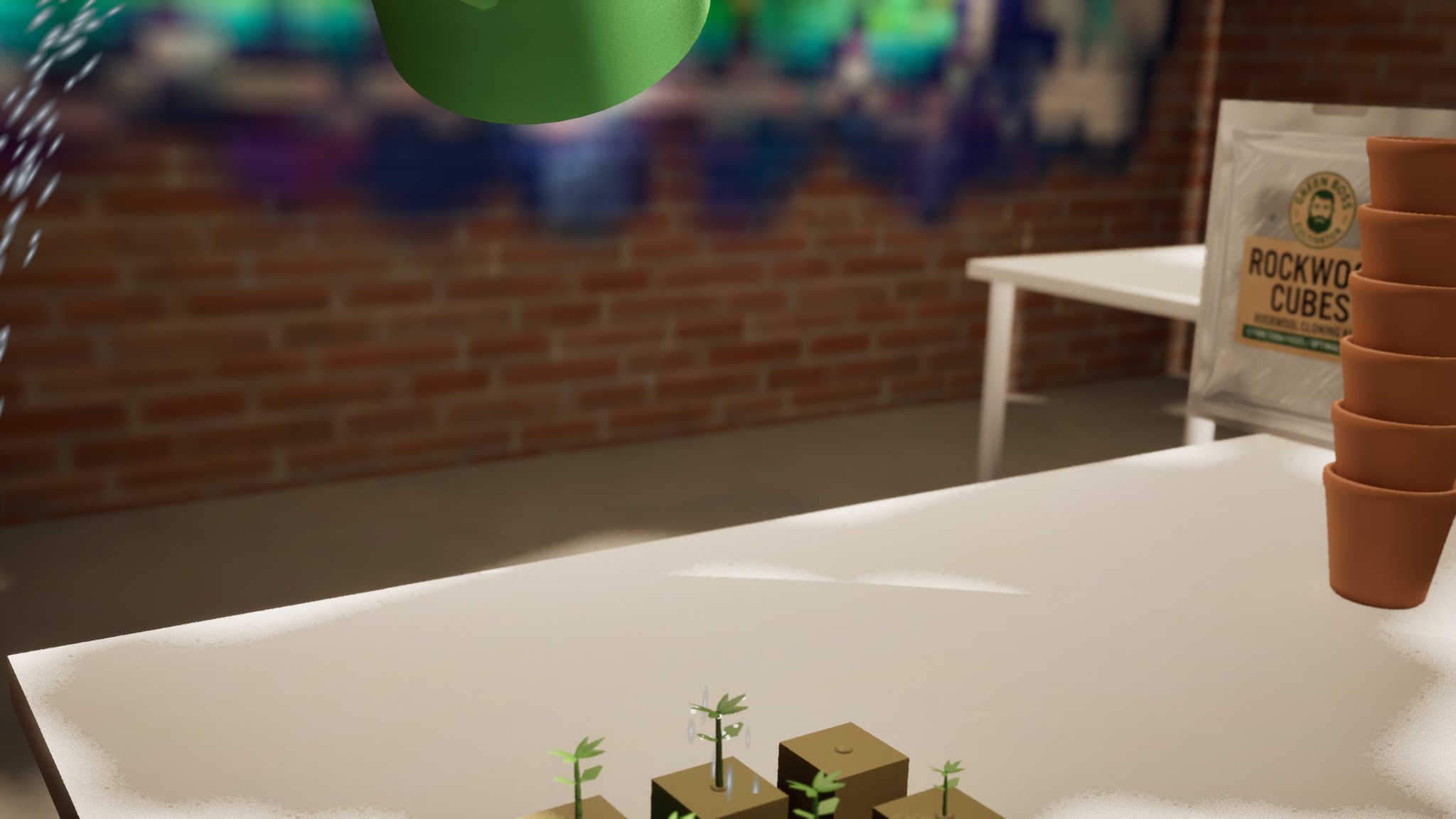 A green watering can pouring over small seedlings in brown cubes on a white table in a brick cellar. Water drips off the leaves; a stack of terracotta pots and a Green Boss rockwool bag sit out of focus to the right.