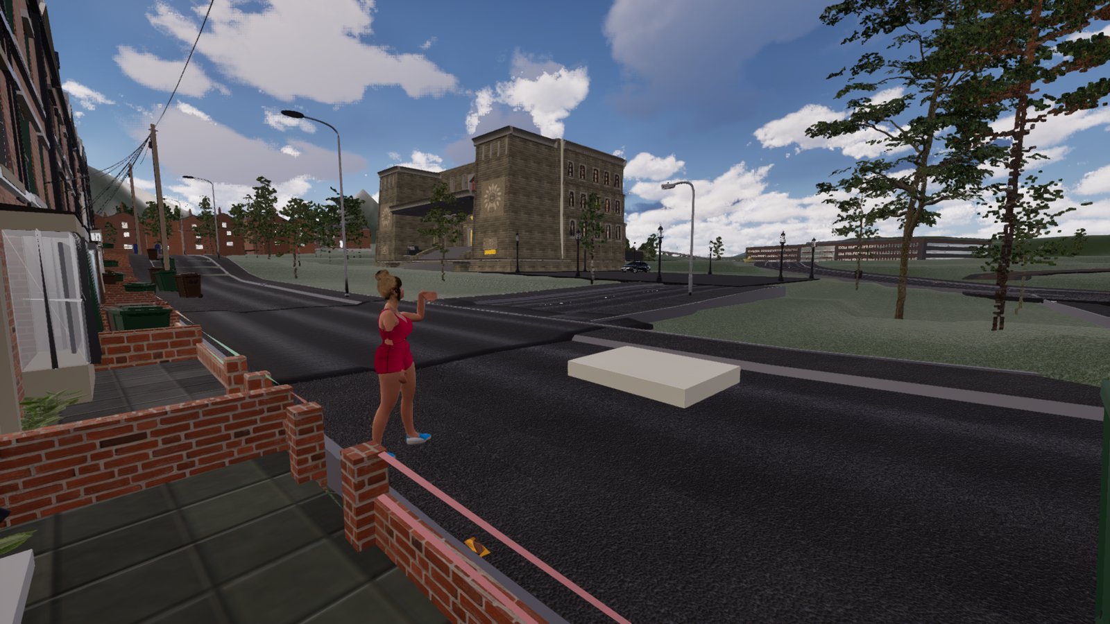 A woman in a red dress stands on top of the corner pier of a low brick garden wall in front of a terraced house, holding a phone up towards a white mattress lying in the road, with a large stone building beyond.