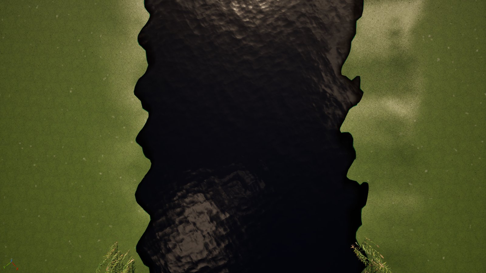 A near-vertical view straight down at a river channel running between two green grass banks. The water fills the middle of the frame and is almost black, with a faint rippled highlight at the top.