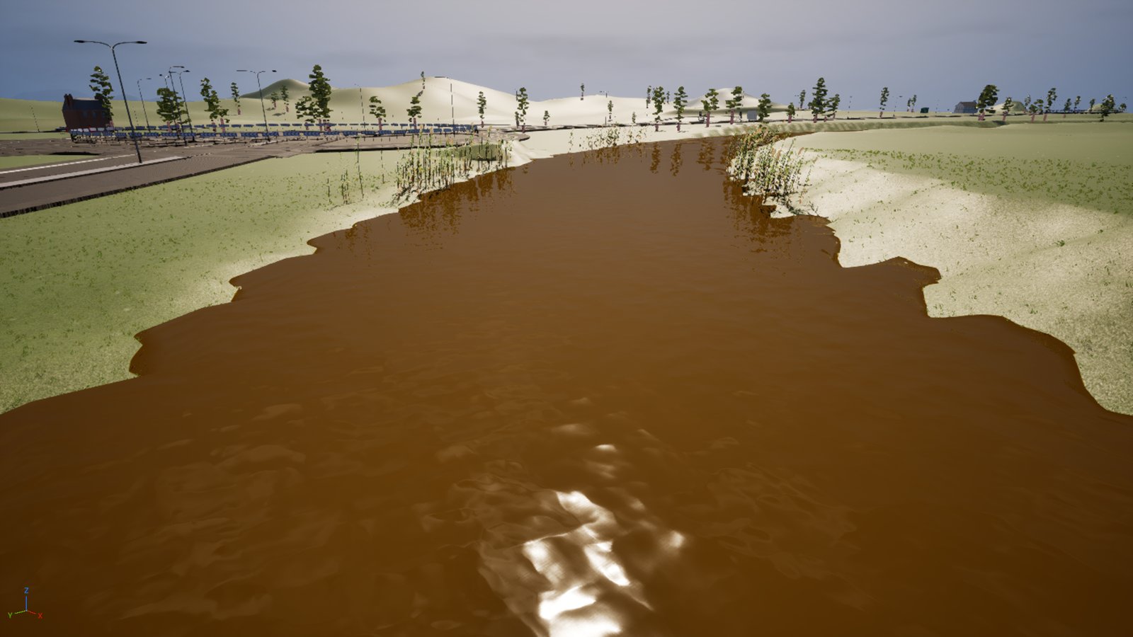 The same river reach with the water an opaque orange-brown, like a river in flood, reeds along both margins and the same road and railings on the left.