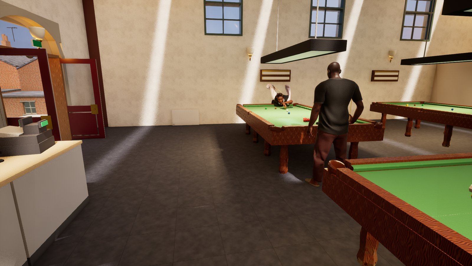 A man is down on a snooker shot at the far side of a table in a sunlit club room, but his body is square to the table with both arms flung out sideways and the cue lying across his chest rather than along his line of sight. A second man in a dark t-shirt stands close beside the table watching. A bar counter with a till and a glazed door onto a brick street fill the left of the frame.