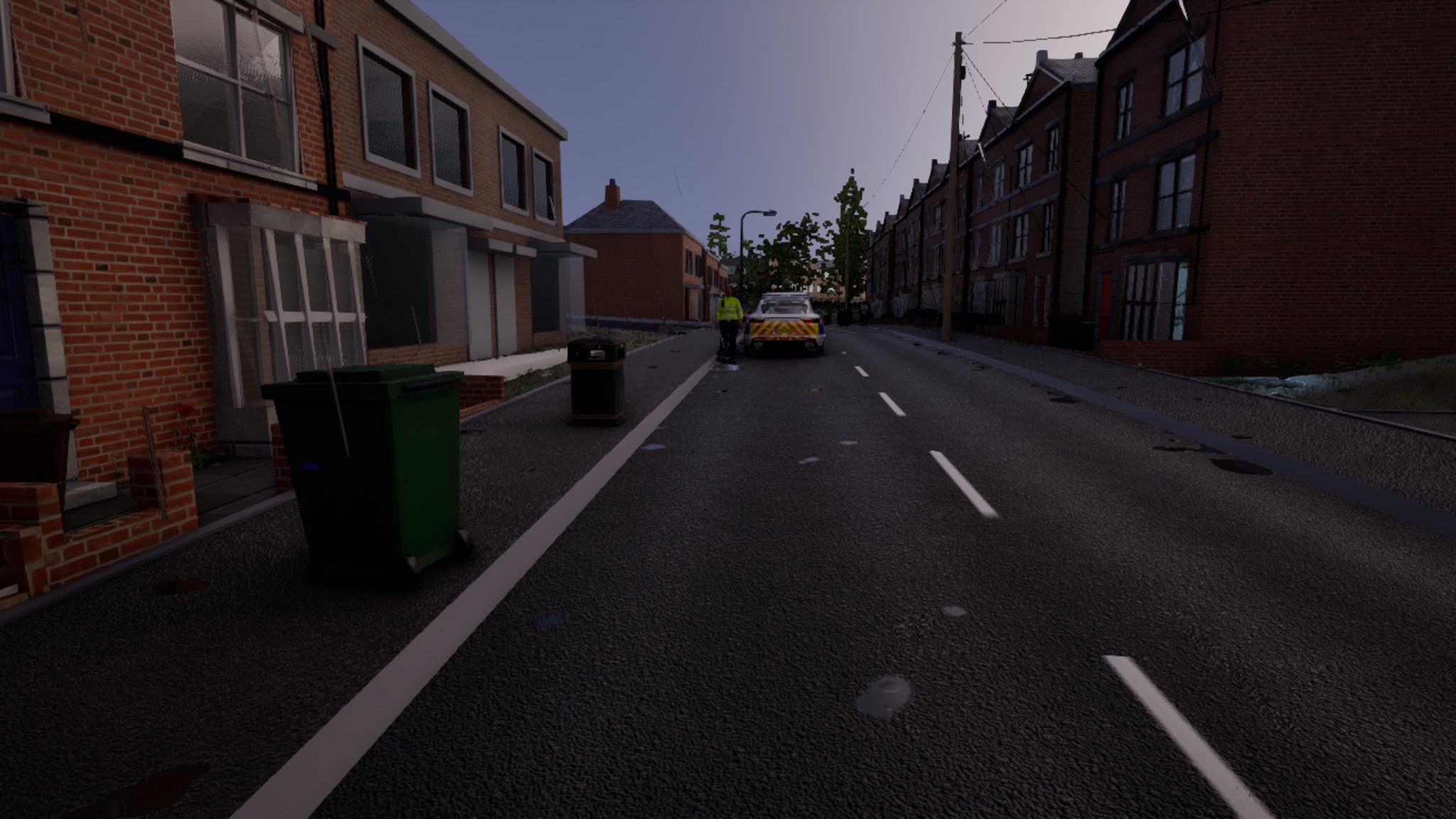 Dusk on a red-brick terraced street, a green wheelie bin on the near kerb. Far down the road a police car with yellow and blue squares is stopped, and an officer in a hi-vis jacket stands beside it.