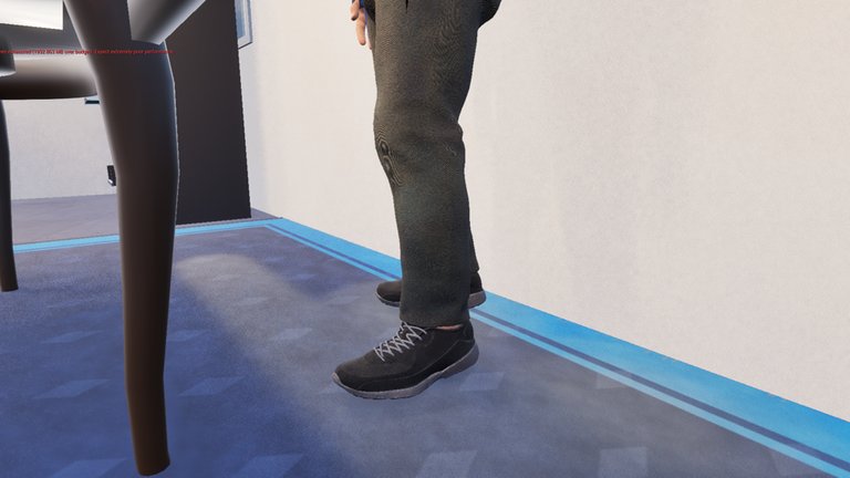 The same man's legs and feet on the same betting shop carpet after the fix: the trainer is now black with a plain dark grey sole and grey laces, and the blue has gone entirely. A red engine warning about video memory runs across the top left of the editor viewport.