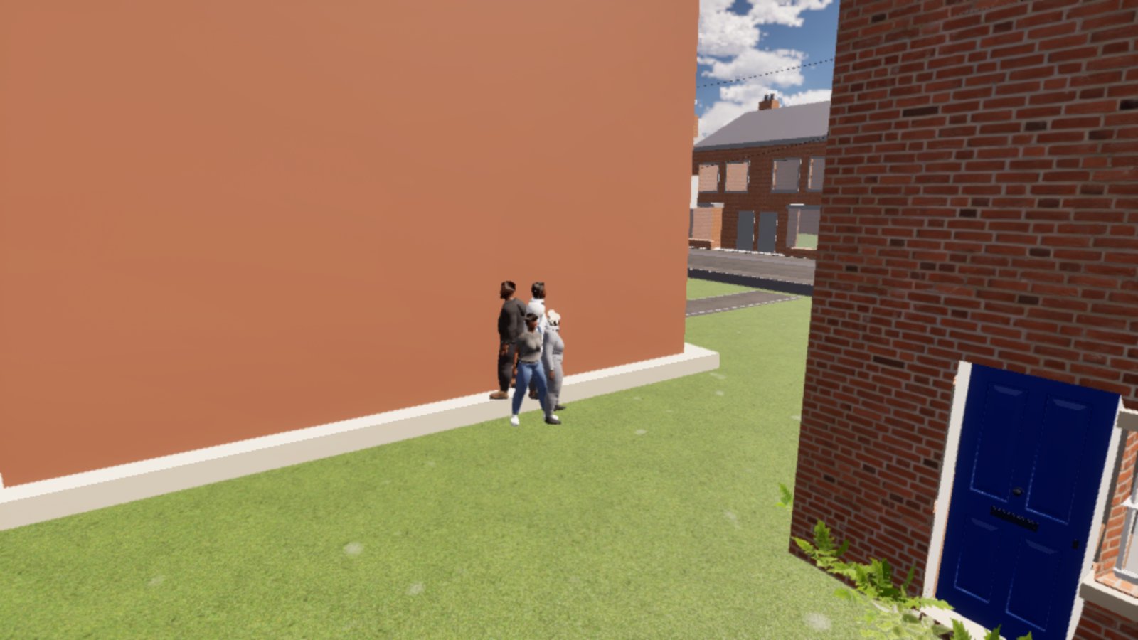 Four people standing close together against a plain orange-brown side wall of a building, on a strip of grass. A red-brick house with a blue front door is in the foreground on the right.