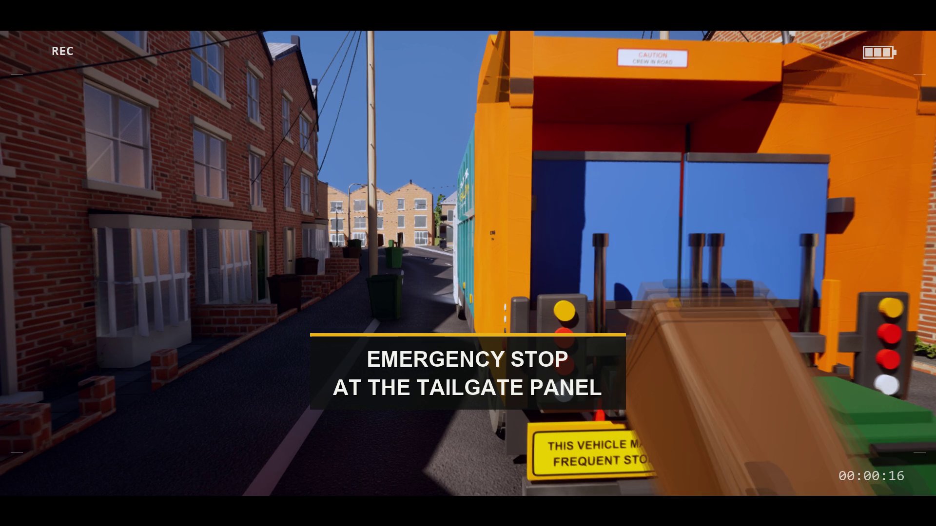 A frame of the induction film: the tailgate control panel with its column of lights, captioned EMERGENCY STOP AT THE TAILGATE PANEL.