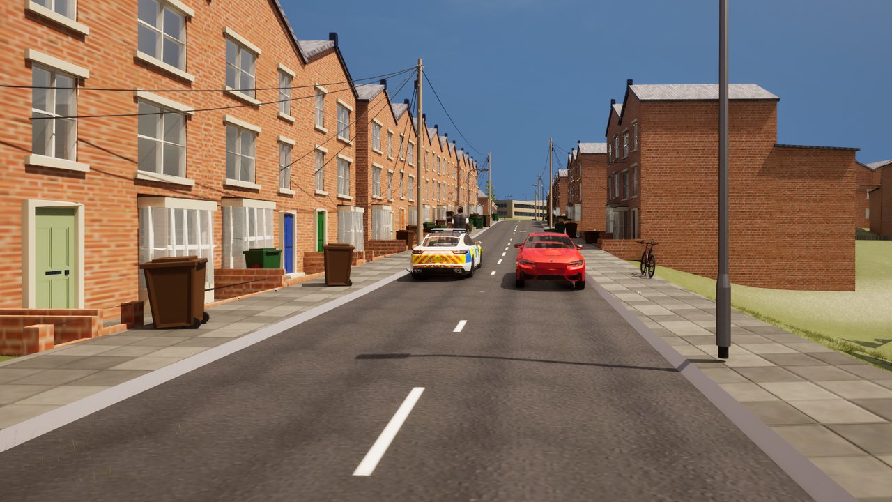 A long street of red-brick terraced houses with wheelie bins by the front walls, and a police patrol car in blue and yellow checks on the road ahead beside a red car.