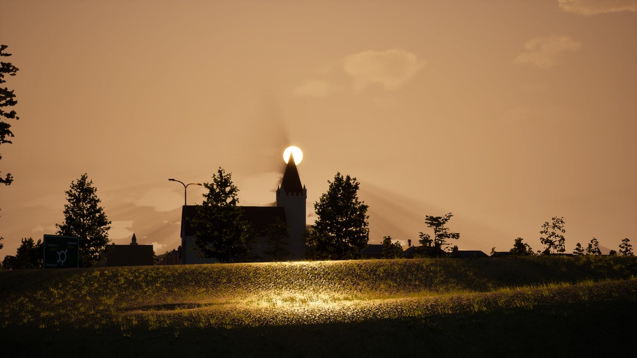 A low sun sitting right on top of a church spire, trees in silhouette either side, and a wet field in the foreground catching the light.